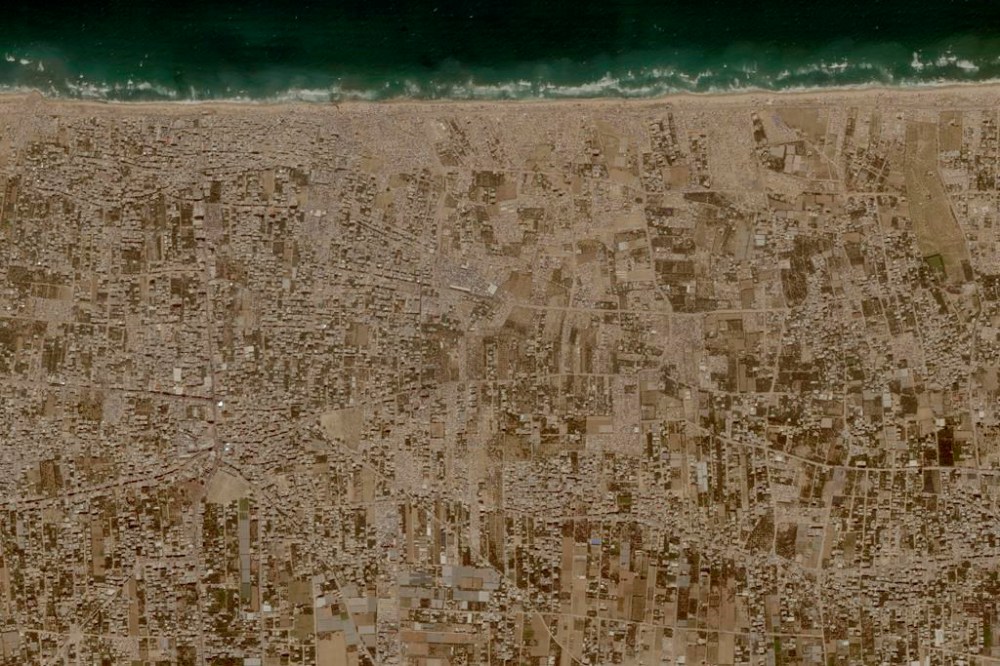 This image provided by Planet Labs PBC shows tent camps line the beach and fill empty lots outside the central Gaza city of Deir al-Balah, Friday, May 24, 2024, housing Palestinians who fled Israel's offensive in Rafah the past three weeks. (Planet Labs PBC via AP)