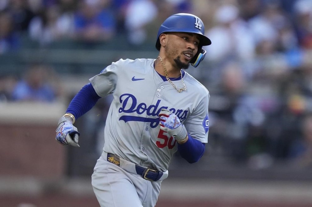 Los Angeles Dodgers' Mookie Betts (50) runs to first base for an RBI single during the tenth inning in the first baseball game of a doubleheader against the New York Mets Tuesday, May 28, 2024, in New York. (AP Photo/Frank Franklin II)