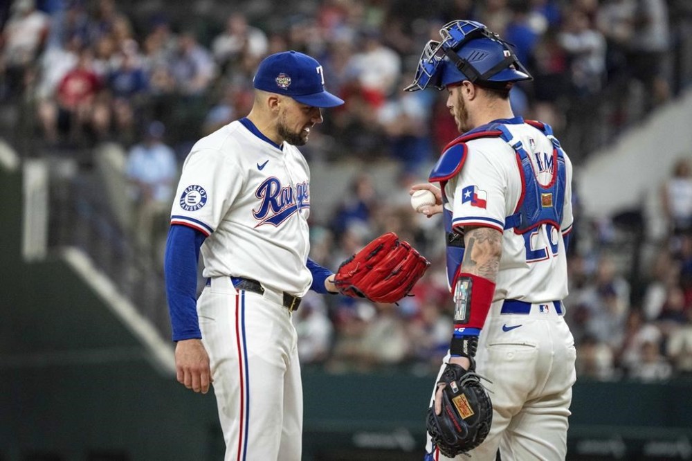 Texas Rangers starting pitcher Nathan Eovaldi takes the ball from catcher Jonah Heim after having given two runs to the Arizona Diamondbacks during the second inning of a baseball game Tuesday, May 28, 2024, in Arlington, Texas. (AP Photo/Jeffrey McWhorter)