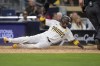 San Diego Padres' Luis Arraez scores from second base off an RBI singly by San Diego Padres' Jurickson Profar during the fifth inning of a baseball game against the Miami Marlins, Tuesday, May 28, 2024, in San Diego. (AP Photo/Gregory Bull)