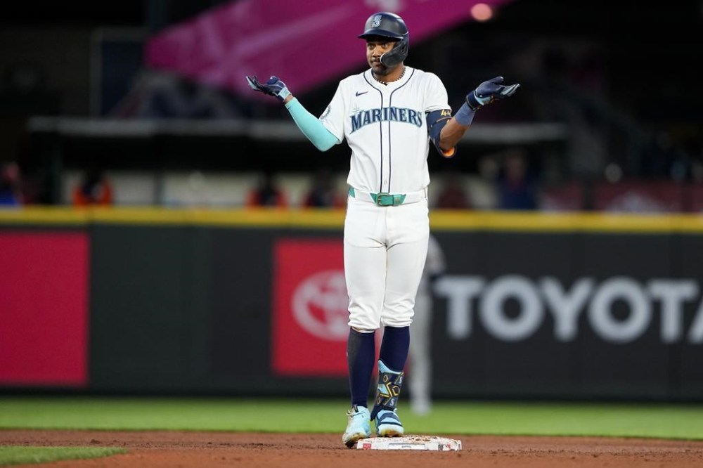 Seattle Mariners' Julio Rodríguez reacts after hitting an RBI single and reaching second base on a throwing error by Houston Astros third baseman Alex Bregman during the eighth inning of a baseball game Tuesday, May 28, 2024, in Seattle. (AP Photo/Lindsey Wasson)