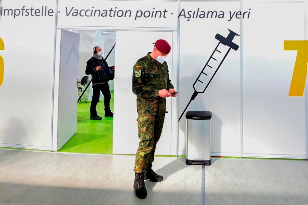 FILE - A soldier of the German Armed Forces Bundeswehr stands inside a new vaccination centre at the former Tempelhof airport in Berlin, Germany, before its opening on Monday, March 8, 2021. Germany has scrapped a requirement for its military servicepeople to be vaccinated against COVID-19. Members of the German military, the Bundeswehr, are required to get vaccinations against a number of diseases — including measles, mumps and flu. COVID-19 was added to the list in November 2021, meaning that anyone who refused to get vaccinated against it could face disciplinary measures. (Tobias Schwarz / Pool via AP, File)