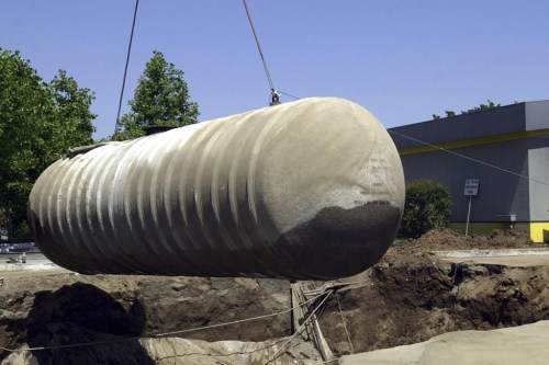 FILE - Workers remove a 10,000-gallon underground gasoline storage tank to be replaced with a new tank at a gas station in Sacramento, Calif., May 23, 2003. Nearly half of Americans depend on groundwater for their drinking water, according to the Environmental Protection Agency. Environmental experts say even a pinprick-size hole in an underground tank can send 400 gallons of fuel a year into the ground, polluting soil and water. (AP Photo/Rich Pedroncelli, File)