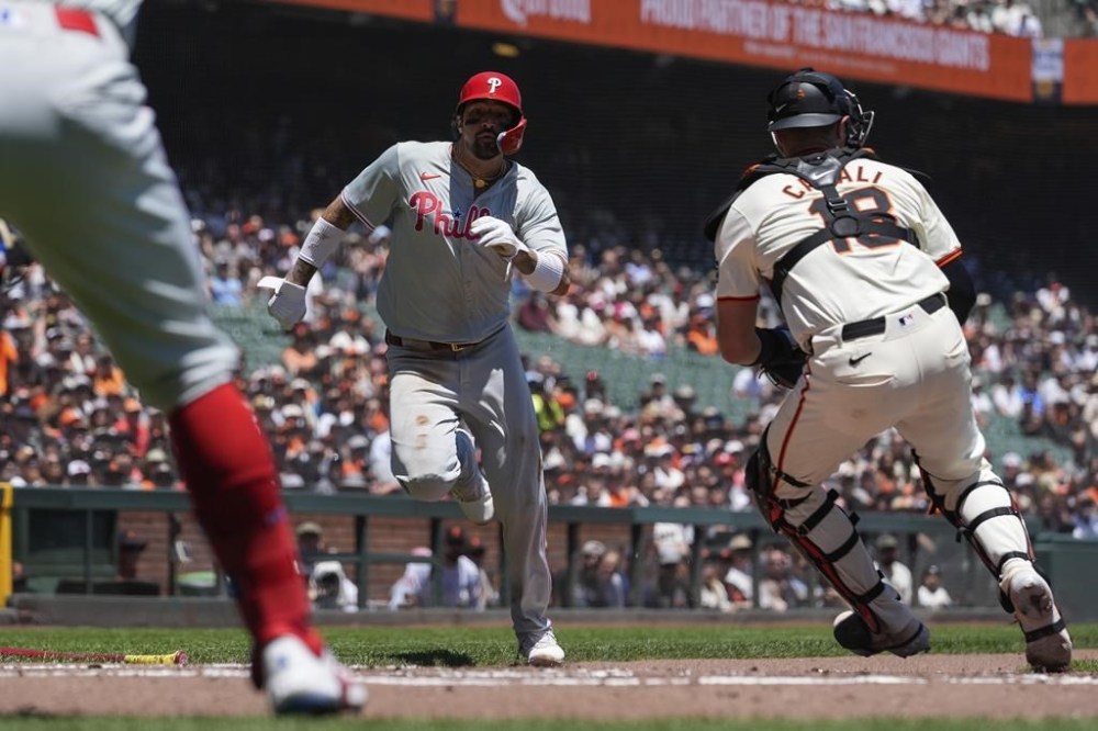 Philadelphia Phillies' Nick Castellanos, center, scores past San Francisco Giants catcher Curt Casali on Cristian Pache's single during the second inning of a baseball game Wednesday, May 29, 2024, in San Francisco. (AP Photo/Godofredo A. Vásquez)