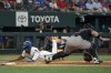 Texas Rangers' Adolis García scores in front of Arizona Diamondbacks catcher Tucker Barnhart on a single by Wyatt Langford during the eighth inning of a baseball game Wednesday, May 29, 2024, in Arlington, Texas. (AP Photo/Jeffrey McWhorter)