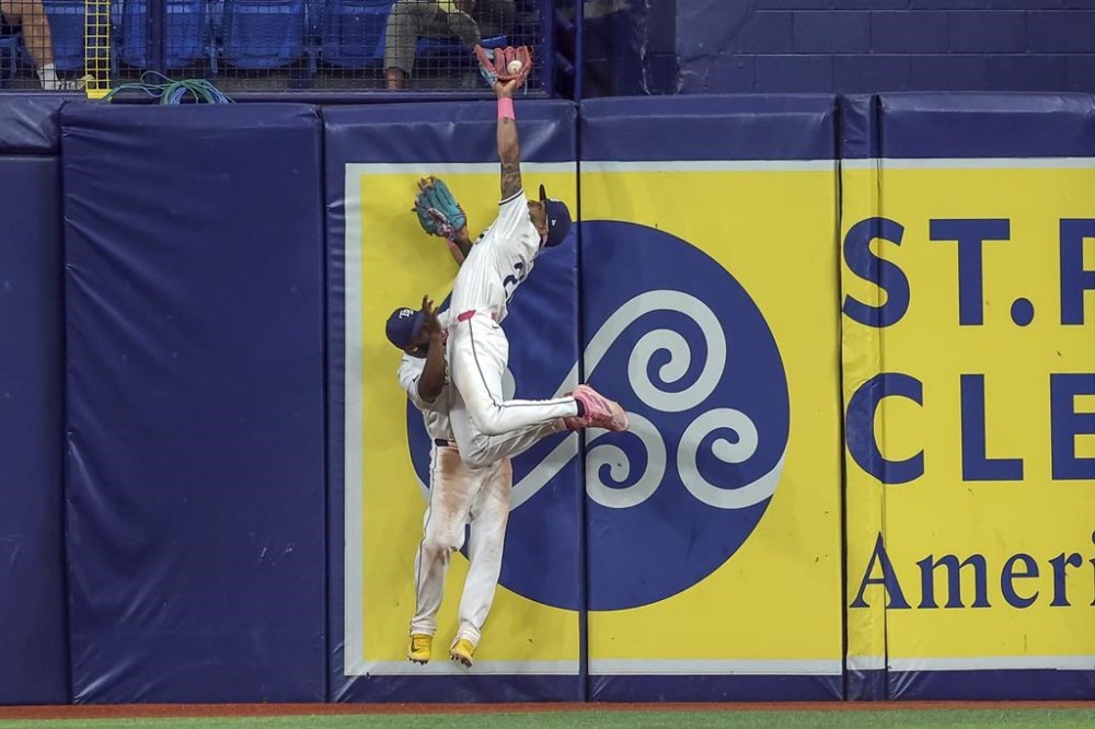 Tampa Bay Rays' Jose Siri makes a catch on a fly ball from Oakland Athletics' Zack Gelof as he collides with Randy Arozarena during the ninth inning of a baseball game Wednesday, May 29, 2024, in St. Petersburg, Fla. (AP Photo/Mike Carlson)