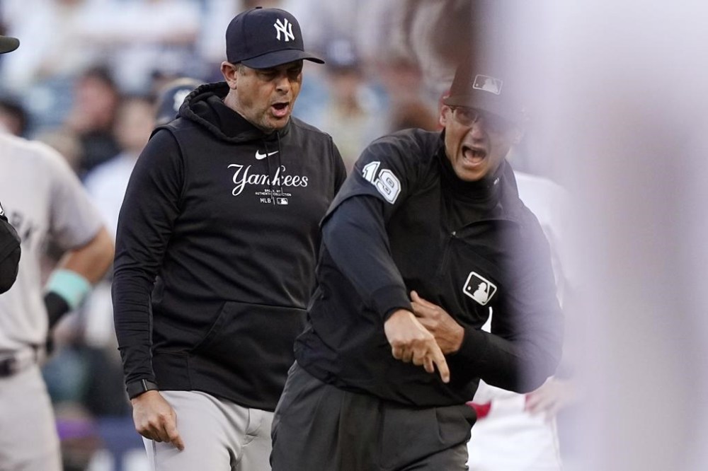 New York Yankees manager Aaron Boone, left, is thrown out of the game by second base umpire Vic Carapazza during the first inning of a baseball game against the Los Angeles Angels Wednesday, May 29, 2024, in Anaheim, Calif. Boone argued after Juan Soto was called out at second for runner's interference. (AP Photo/Mark J. Terrill)