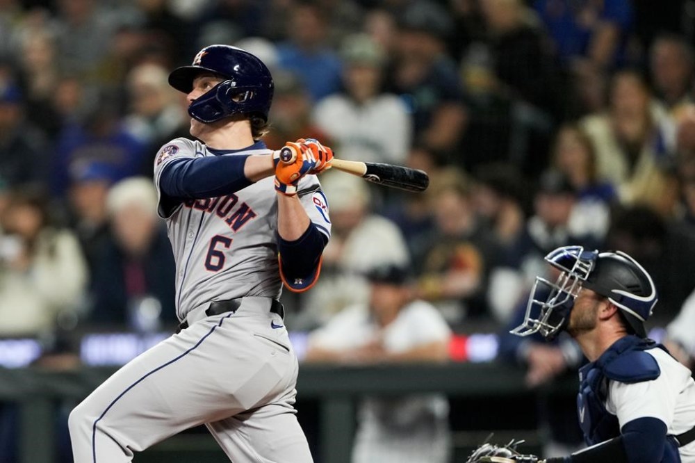 Houston Astros' Jake Meyers hits an RBI single as Seattle Mariners catcher Mitch Garver looks on during the fourth inning of a baseball game, Wednesday, May 29, 2024, in Seattle. (AP Photo/Lindsey Wasson)