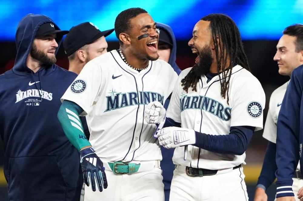 Seattle Mariners' J.P. Crawford, right, celebrates with Julio Rodríguez after Crawford drove in the winning run against the Houston Astros with a sacrifice fly during the 10th inning of a baseball game Wednesday, May 29, 2024, in Seattle. The Mariners won 2-1. (AP Photo/Lindsey Wasson)