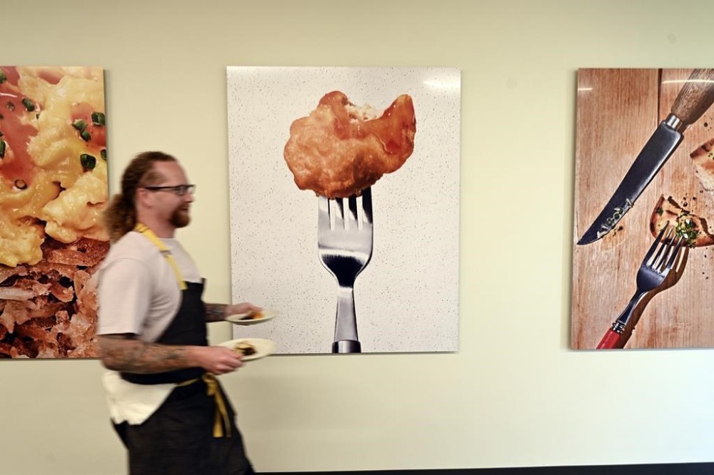 FILE - Chef Zach Tyndall carries plates of cultivated chicken at GOOD Meat's Alameda, Calif., headquarters on Sept. 28, 2023. Lab-grown meat is not currently available in any U.S. grocery stores or restaurants. If some lawmakers have their way, it never will be. (AP Photo/Noah Berger, File)