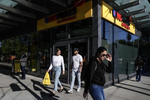 Customers walk out with their shopping from a new 