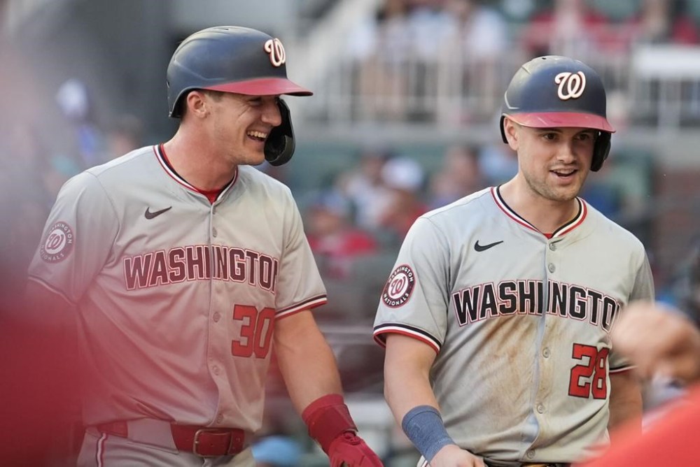 Washington Nationals' Jacob Young (30) and Lane Thomas (28) celebrate after scoring in the third inning of a baseball game against the Atlanta Braves,Thursday, May 30, 2024, in Atlanta. (AP Photo/Brynn Anderson)