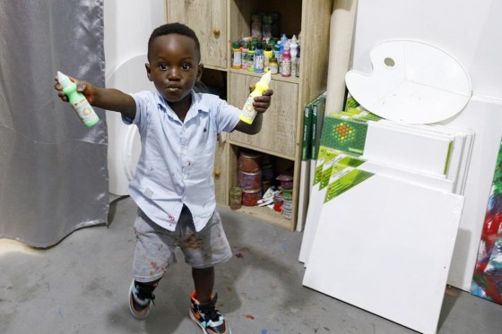 Ace-Liam Nana Sam Ankrah, who will turn two in July, shows off his paint tubes at his mother's art gallery in Accra, Ghana, Monday. (Misper Apawu / The Associated Press files)