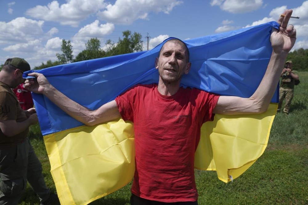 A Ukrainian serviceman reacts after returning from captivity during POWs exchange in Sumy region, Ukraine, Friday, May 31, 2024. Ukraine returned 75 prisoners, including four civilians, in the latest exchange of POWs with Russia. It's the fourth prisoner swap this year, and 52nd since Russia invaded Ukraine. In all, 3 210 Ukrainian servicemen and civilians were returned since the outbreak of the war. (AP Photo/Evgeniy Maloletka)