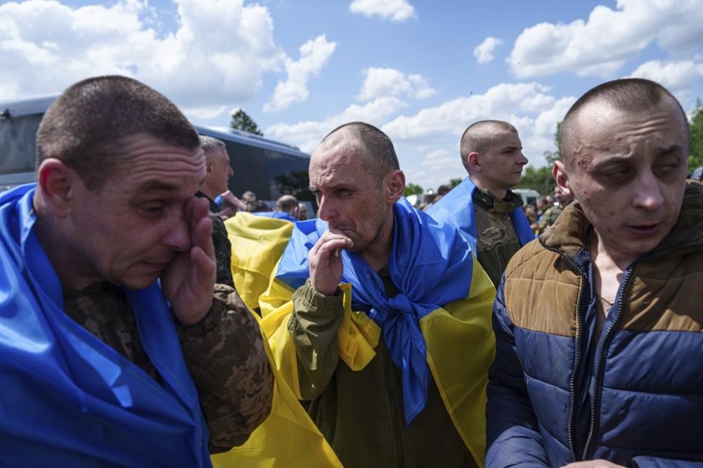 Ukrainian servicemen reacts after returning from captivity during POWs exchange in Sumy region, Ukraine, Friday, May 31, 2024. Ukraine returned 75 prisoners, including four civilians, in the latest exchange of POWs with Russia. It's the fourth prisoner swap this year, and 52nd since Russia invaded Ukraine. In all, 3 210 Ukrainian servicemen and civilians were returned since the outbreak of the war. (AP Photo/Evgeniy Maloletka)