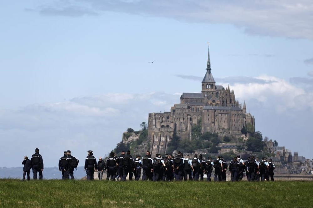 Gendarmes patrol in front of the Mont-Saint-Michel before the Olympic torch relay arrives at the famous island, Friday, May 31, 2024 in Brittany. (AP Photo/Jeremias Gonzalez)