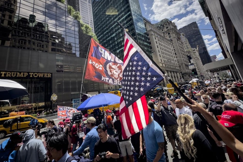 A supporter of former President Donald Trump waves an inverted American flag during a demonstration outside Trump Tower, Friday, May 31, 2024, in New York. A day after a New York jury found Trump guilty of 34 felony charges, the presumptive Republican presidential nominee addressed the conviction and likely attempt to cast his campaign in a new light. (AP Photo/John Minchillo)