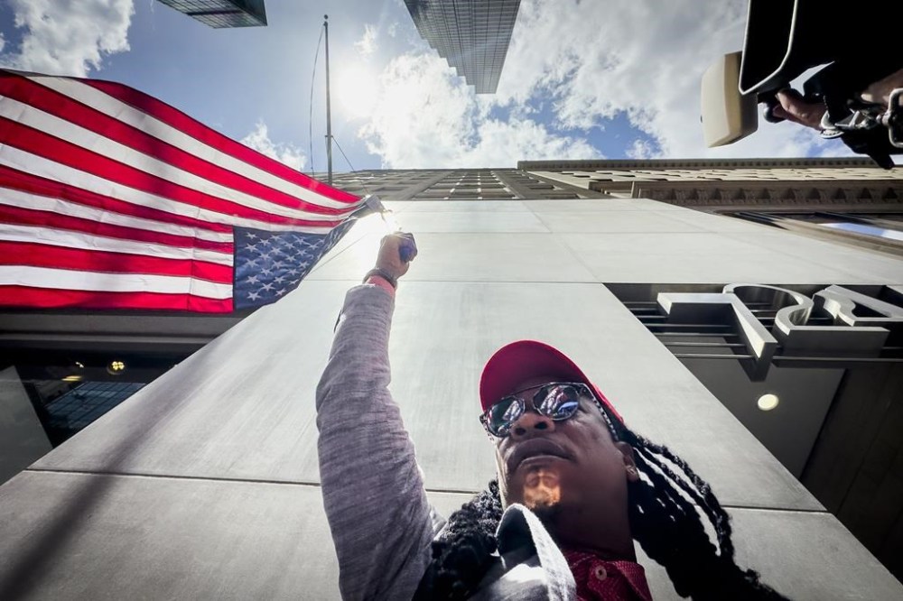 A supporter of former President Donald Trump waves an inverted American flag during a demonstration outside Trump Tower, Friday, May 31, 2024, in New York. A day after a New York jury found Trump guilty of 34 felony charges, the presumptive Republican presidential nominee addressed the conviction and likely attempt to cast his campaign in a new light. (AP Photo/John Minchillo)