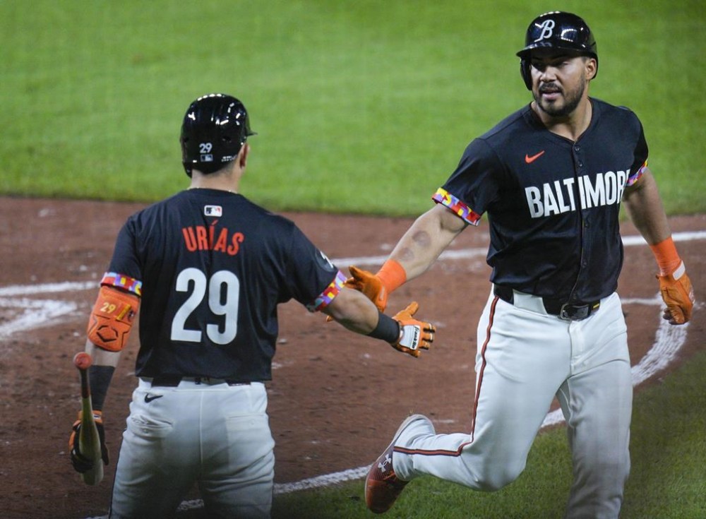 Baltimore Orioles' Anthony Santander, right, slaps handswith Ramón Urías (29) after scoring against the Tampa Bay Rays on a hit by Austin Hays during the sixth inning of a baseball game, Friday, May 31, 2024, in Baltimore. (AP Photo/Jess Rapfogel)