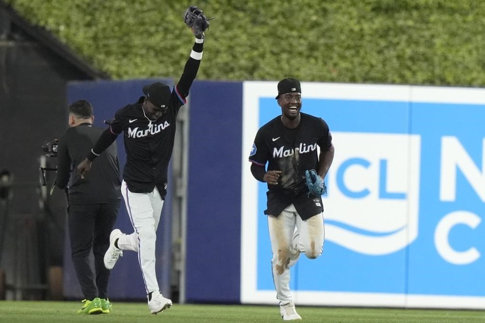 Miami Marlins left fielder Nick Gordon, left, and right fielder Jesus Sanchez, right, celebrate after they defeated the Texas Rangers in a baseball game Friday, May 31, 2024, in Miami. (AP Photo/Lynne Sladky)