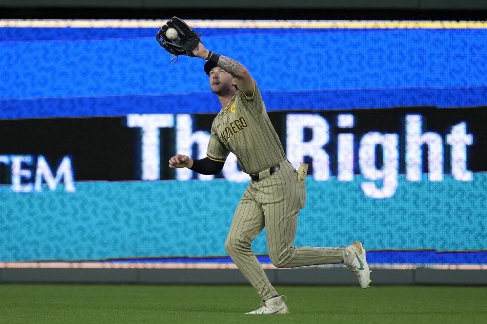 San Diego Padres center fielder Jackson Merrill catches a fly ball for the out on Kansas City Royals' Adam Frazier during the fifth inning of a baseball game Friday, May 31, 2024, in Kansas City, Mo. (AP Photo/Charlie Riedel)