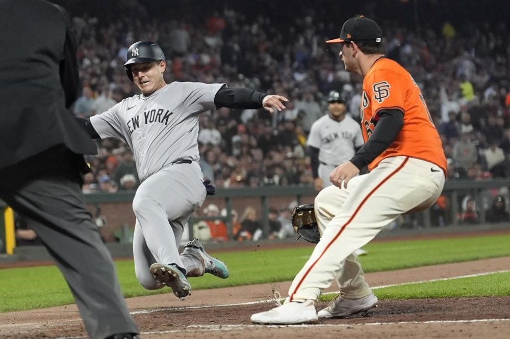 New York Yankees' Anthony Rizzo, left, slides home to score past San Francisco Giants first baseman Trenton Brooks during the sixth inning of a baseball game in San Francisco, Friday, May 31, 2024. (AP Photo/Jeff Chiu)