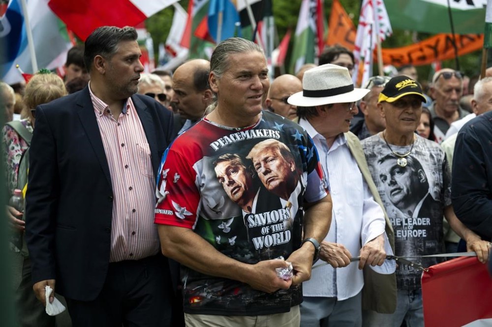 A man wearing a T-shirt showing Viktor Orbán and Donald Trump, attends a