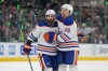Edmonton Oilers' Adam Henrique (19) and Philip Broberg (86) celebrate after Broberg scored against the Dallas Stars during the second period of Game 5 of the Western Conference finals in the NHL hockey Stanley Cup playoffs Friday, May 31, 2024, in Dallas. (AP Photo/Julio Cortez)