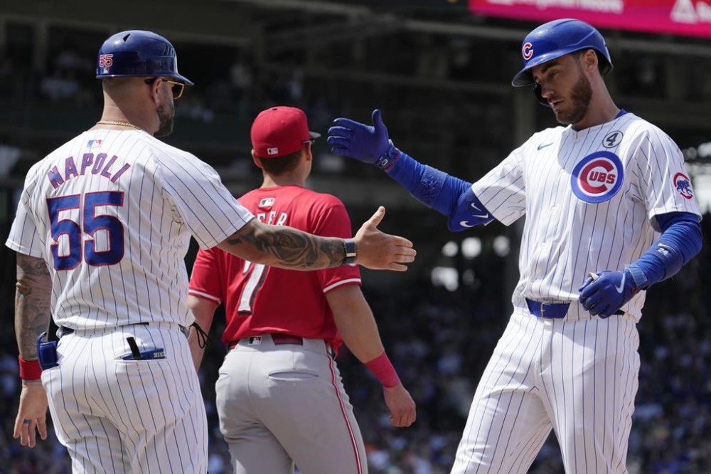 Chicago Cubs' Cody Bellinger, right, celebrates with first base coach Mike Napoli, left, after hitting a one-run single during the fifth inning of a baseball game against the Cincinnati Reds in Chicago, Sunday, June 2, 2024. (AP Photo/Nam Y. Huh)