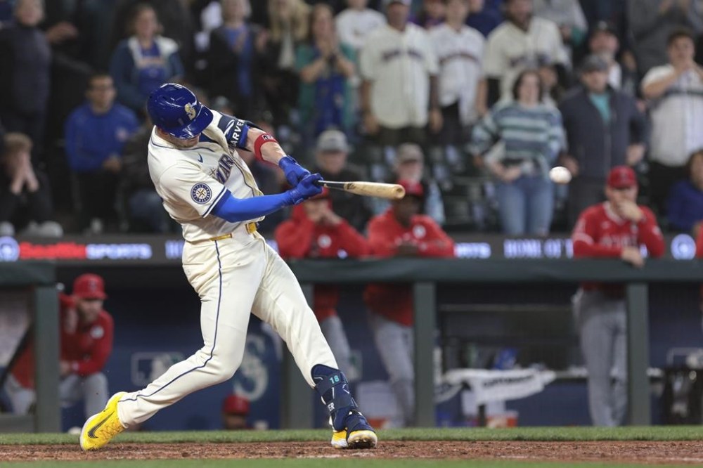 Seattle Mariners' Mitch Garver hits a three-run double off a pitch by Los Angeles Angels pitcher Luis García to score Julio Rodríguez, Ty France and Luke Raley during the eighth inning of a baseball game, Sunday, June 2, 2024, in Seattle. (AP Photo/Jason Redmond)