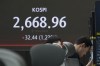 A currency trader reacts near the screen showing the Korea Composite Stock Price Index (KOSPI) at the foreign exchange dealing room of the KEB Hana Bank headquarters in Seoul, South Korea, Monday, June 3, 2024. (AP Photo/Ahn Young-joon)
