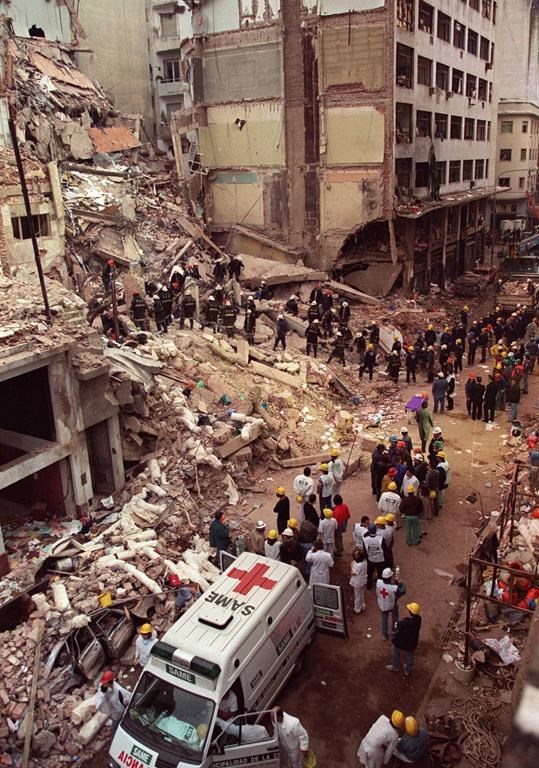 FILE - Firefighters and rescue workers search through the rubble of the Argentine Jewish Mutual Association, a community center known by its Spanish acronym AMIA, after a car bomb rocked the building, killing 85 people, in Buenos Aires, Argentina, July 18, 1994. (AP Photo/Alejandro Pagni, File)