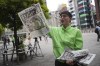 A staff distributes an extra edition of the Yomiuri Shimbun newspaper reporting on Japanese golfer Yuka Saso winning the U.S. Women's Open golf tournament Monday, June 3, 2024, in Tokyo. The Japanese title reads as 