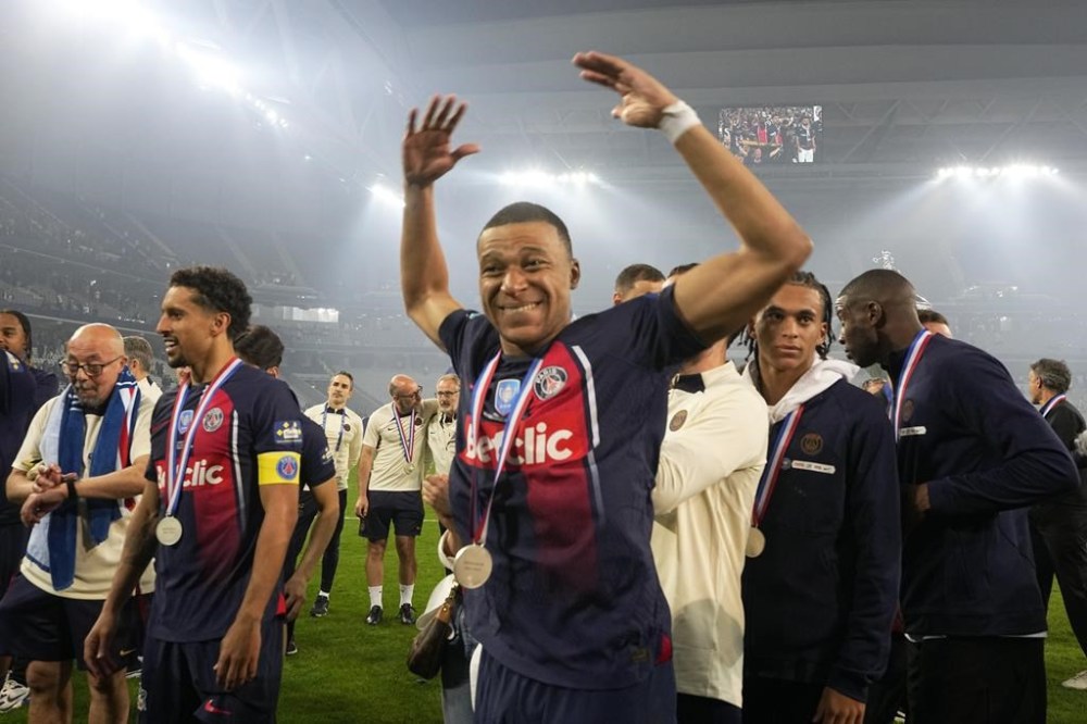PSG's Kylian Mbappe celebrates after the French Cup final soccer match between Lyon and PSG at the Pierre Mauroy stadium in Villeneuve d'Ascq, northern France, Saturday, May 25, 2024. PSG won the match 2-1. (AP Photo/Michel Euler)