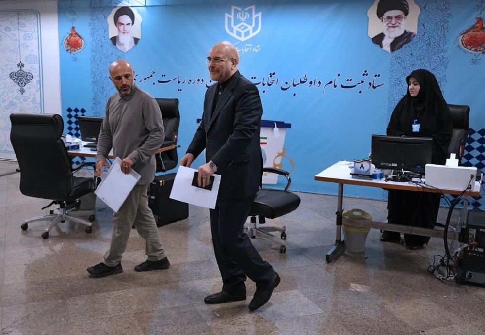 Iran's hard-line parliament speaker Mohammad Bagher Qalibaf, center, walks through the elections headquarters of the country while registering his name as candidate for the June 28 presidential election, in Tehran, Iran, Monday, June 3, 2024. The entry of Qalibaf brings a prominent candidate with close ties to the country's paramilitary Revolutionary Guard into the vote to replace President Ebrahim Raisi, who died in a helicopter crash with seven others on May 19. (AP Photo/Vahid Salemi)