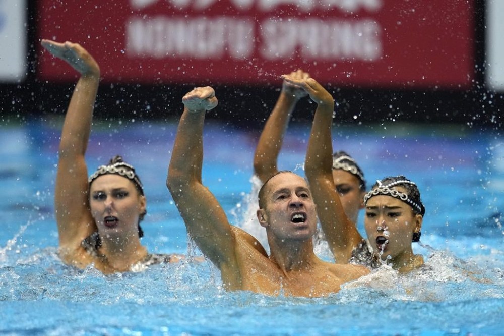FILE - The United Staes team, including Bill May, front left, compete in the team acrobatic of artistic swimming at the World Swimming Championships in Fukuoka, Japan, Saturday, July 15, 2023. May might become the first man to compete in artistic swimming at an Olympics. May, 45, who lives in California, will find out Friday if he is picked by a five-person panel to represent the United States at the Paris Games in the team event for the sport that used to be called synchronized swimming. (AP Photo/Nick Didlick, File)