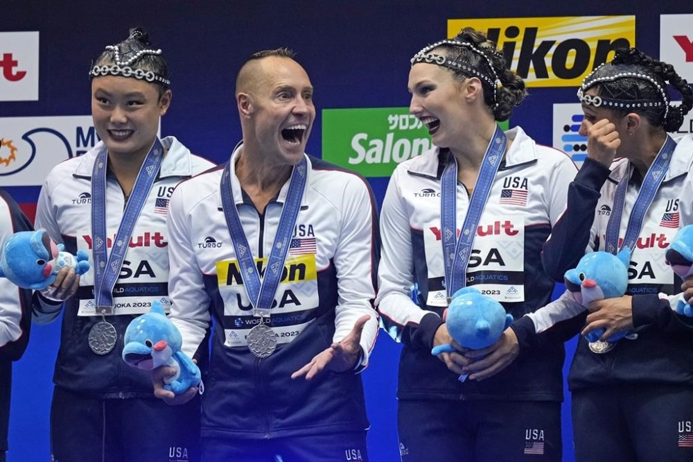 FILE - Bill May, second from left, celebrates with United States teammates after competing in the team acrobatic final of artistic swimming at the World Swimming Championships in Fukuoka, Japan, Monday, July 17, 2023. May might become the first man to compete in artistic swimming at an Olympics. May, 45, who lives in California, will find out Friday if he is picked by a five-person panel to represent the United States at the Paris Games in the team event for the sport that used to be called synchronized swimming. (AP Photo/Nick Didlick, File)