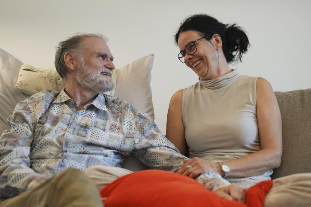 Michael Bommer, left, who is terminally ill with colon cancer, looks at his wife Anett Bommer during a meeting with The Associated Press at his home in Berlin, Germany, Wednesday, May 22, 2024. Bommer, who has only a few more weeks to live, teamed up with friend who runs the AI-powered legacy platform Eternos to