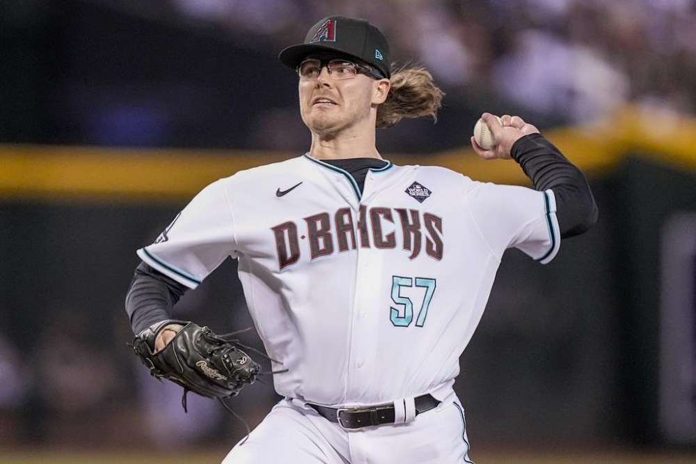 FILE - Arizona Diamondbacks relief pitcher Andrew Saalfrank throws against the Texas Rangers during the ninth inning in Game 3 of the baseball World Series Monday, Oct. 30, 2023, in Phoenix. Major League Baseball, on Tuesday, June 4, 2024, banned Saalfrank for one year after finding the player placed unrelated bets with a legal sportsbook. (AP Photo/Brynn Anderson, FIle)