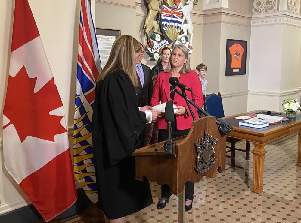 Elenore Sturko, right, is sworn in by clerk Kate Ryan-Lord at the legislature in Victoria, Monday, Oct. 3, 2022. LGBTQ+ advocates in British Columbia say people they've spoken with are confused and disappointed with the decision by an MLA they saw as an ally crossing the floor to join a party she once vocally opposed. THE CANADIAN PRESS/Dirk Meissner