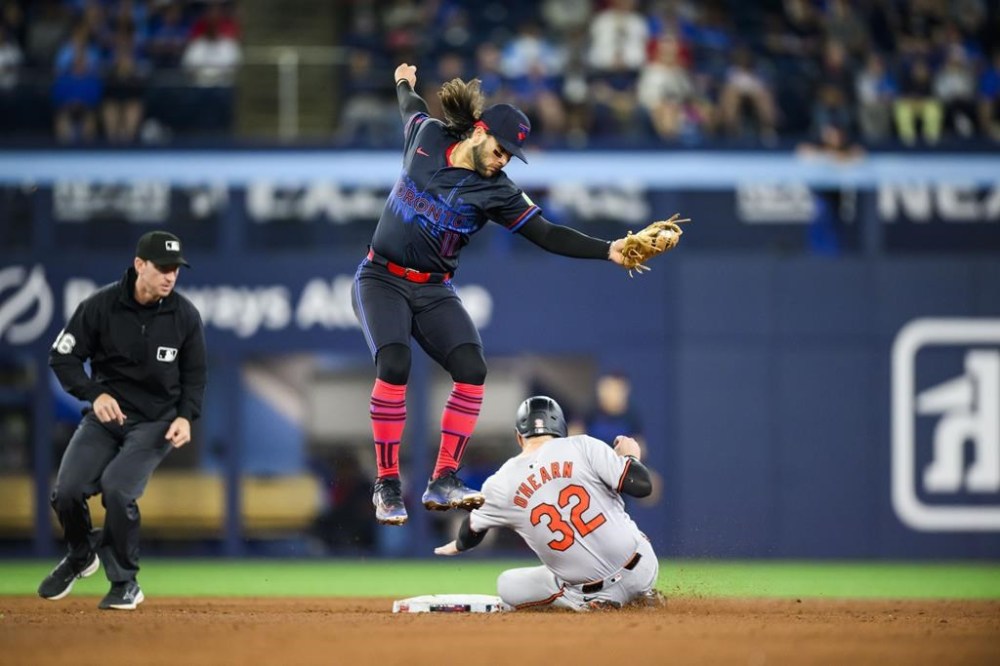 Baltimore Orioles first base Ryan O'Hearn (32) safely steals second base as Toronto Blue Jays shortstop Bo Bichette (11) attempts to make the tag during eighth inning MLB action in Toronto on Monday, June 3, 2024. THE CANADIAN PRESS/Christopher Katsarov