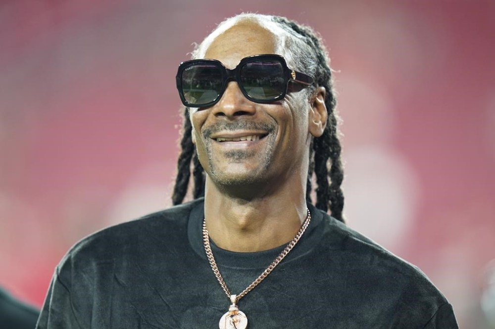 FILE - Entertainer Snoop Dogg walks on the field before an NFL football game between the Tampa Bay Buccaneers and the New Orleans Saints Sunday, Dec. 19, 2021, in Tampa, Fla. Snoop Dogg will serve as a primetime NBC correspondent for Paris Olympics. (AP Photo/Chris O'Meara, File)