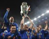 FILE - Italy's Andrea Belotti holds up the trophy after the final of the Euro 2020 soccer final match between England and Italy at Wembley stadium in London, Sunday, July 11, 2021. Just like last time, Italy’s national soccer team is heading into the European Championship following the ignominy of failing to qualify for the World Cup. (Andy Rain/Pool Photo via AP, File)