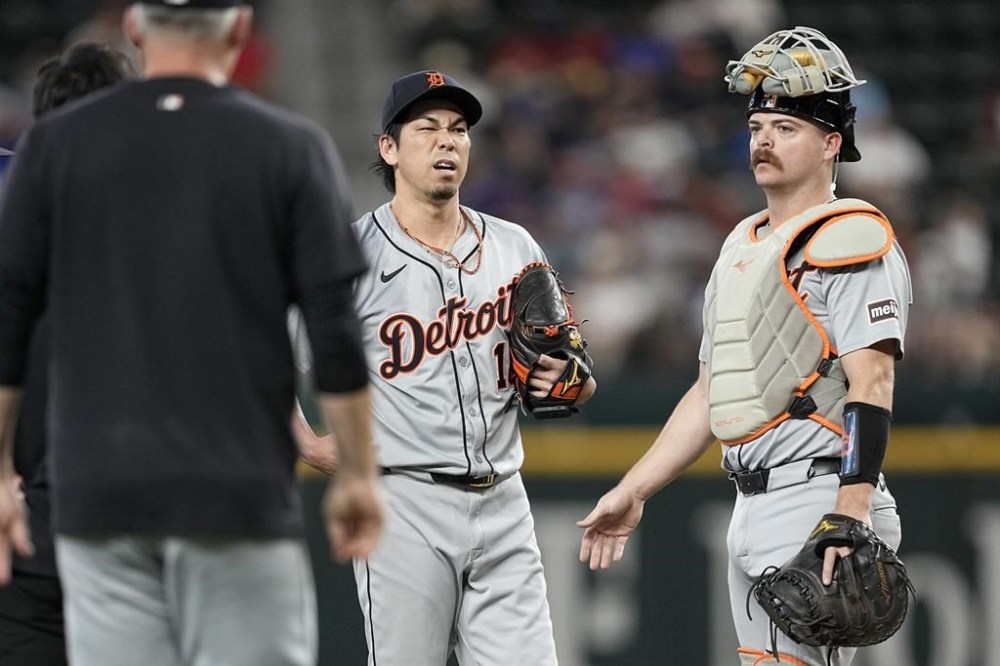Detroit Tigers' Kenta Maeda and catcher Jake Rogers, right, stand by the mound waiting for manager A.J. Hinch, left, during the first inning of the team's baseball game against the Texas Rangers, Wednesday, June 5, 2024, in Arlington, Texas. Maeda left the game. (AP Photo/Tony Gutierrez)
