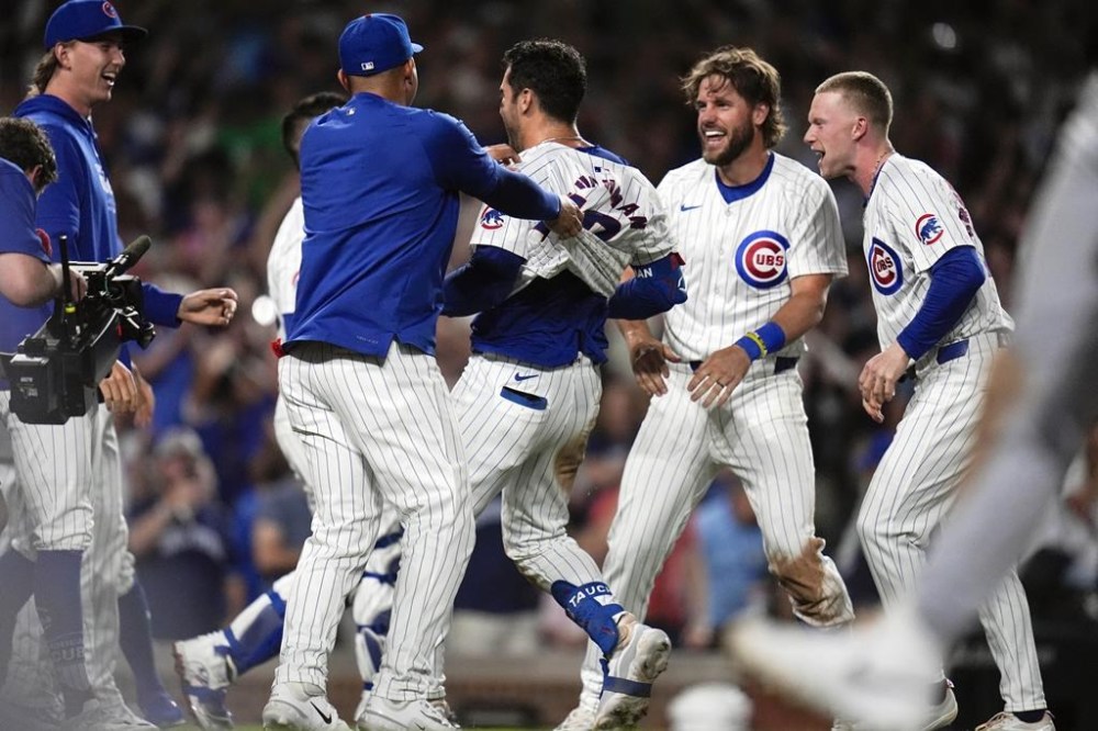 The Chicago Cubs celebrate designated hitter Mike Tauchman's, center, walk-off home run to win the baseball game 7-6 over the Chicago White Sox Wednesday, June 5, 2024, in Chicago. (AP Photo/Erin Hooley)