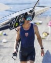 New Zealand's Tom Mackintosh carries his boat after a rowing session on New Zealand's Lake Karapiro, Wednesday April 3 2024. Sitting in an office, with his body sore behind a desk, Mackintosh had enough. After five months in the corporate world, the New Zealander rowing gold-medalist couldn't take it anymore. It was time to get back on the boat to try to win another Olympic medal at the Paris Games. (Stephen Parker/Photosport via AP)
