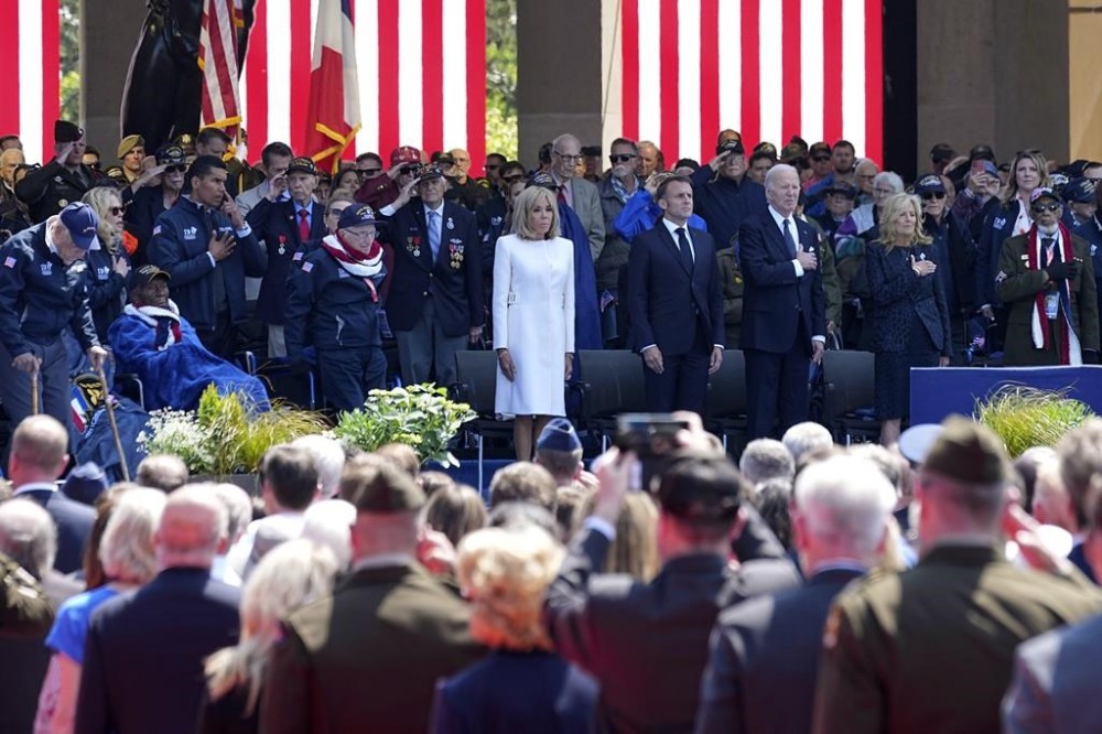 French President Emmanuel Macron, center, his wife Brigitte Macron, center left, and US President Joe Biden, center right, and first lady Jill Biden attend a ceremony together with World War II veterans at an US cemetery near Colleville-sur-Mer Normandy, Thursday, June 6, 2024. World War II veterans from across the United States as well as Britain and Canada are in Normandy this week to mark 80 years since the D-Day landings that helped lead to Hitler's defeat. (AP Photo/Laurent Cipriani)