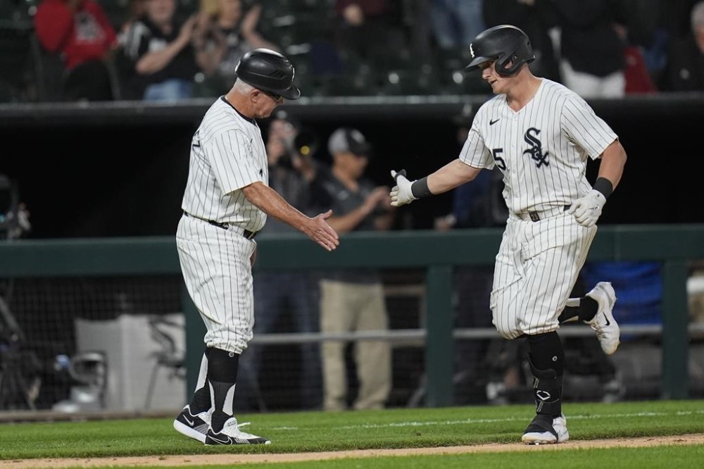 Chicago White Sox's Andrew Vaughn, right, slaps hands with third base coach Eddie Rodriguez after hitting a home run against the Boston Red Sox during the sixth inning of a baseball game Friday, June 7, 2024, in Chicago. (AP Photo/Erin Hooley)