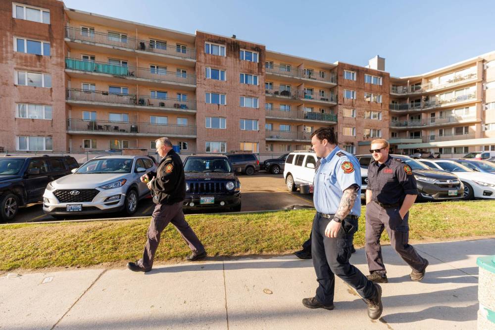 Members of the Winnipeg Fire Paramedic Service arrive shortly before 8 a.m., the deadline to closing the building. (Mike Deal / Free Press)