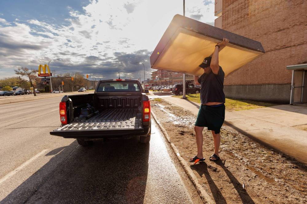 Ryan Ducharme loads his bed onto his sister’s pick-up truck. (Mike Deal / Free Press)